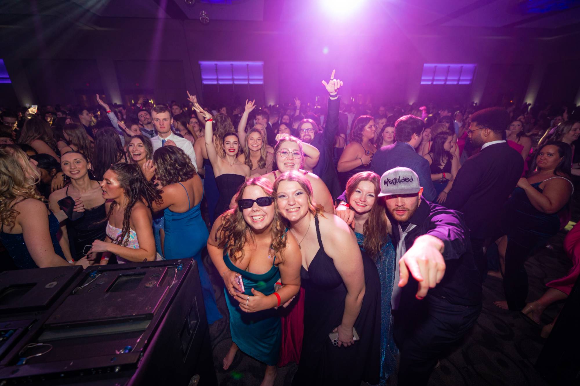 Students dancing, smiling, and pointing at the camera at Presidents' Ball